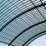 low angle shot of a glass roof of a modern building under the blue sky